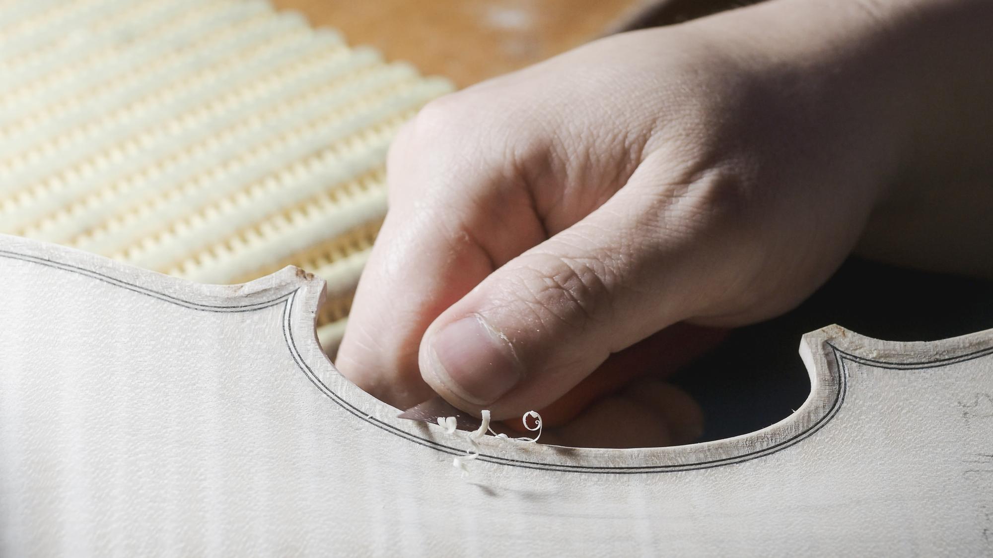 Artisan stitching embroidered initials on canvas