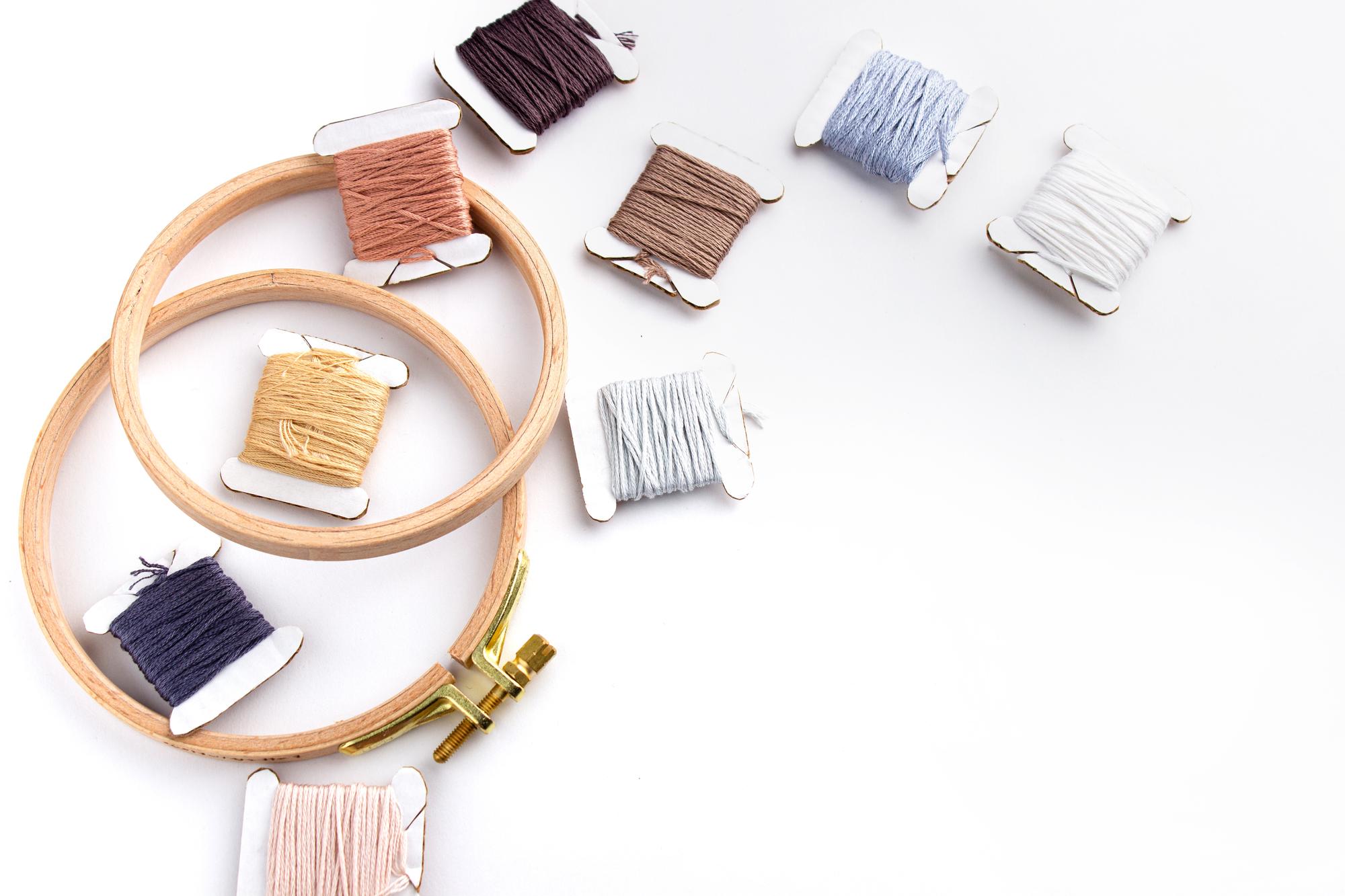 Workshop table with threads, hoops and embroidered samples